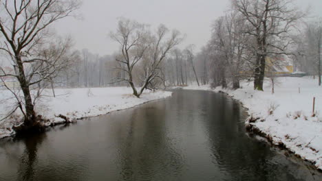 el río fluye lentamente en un paisaje invernal cubierto de nieve
