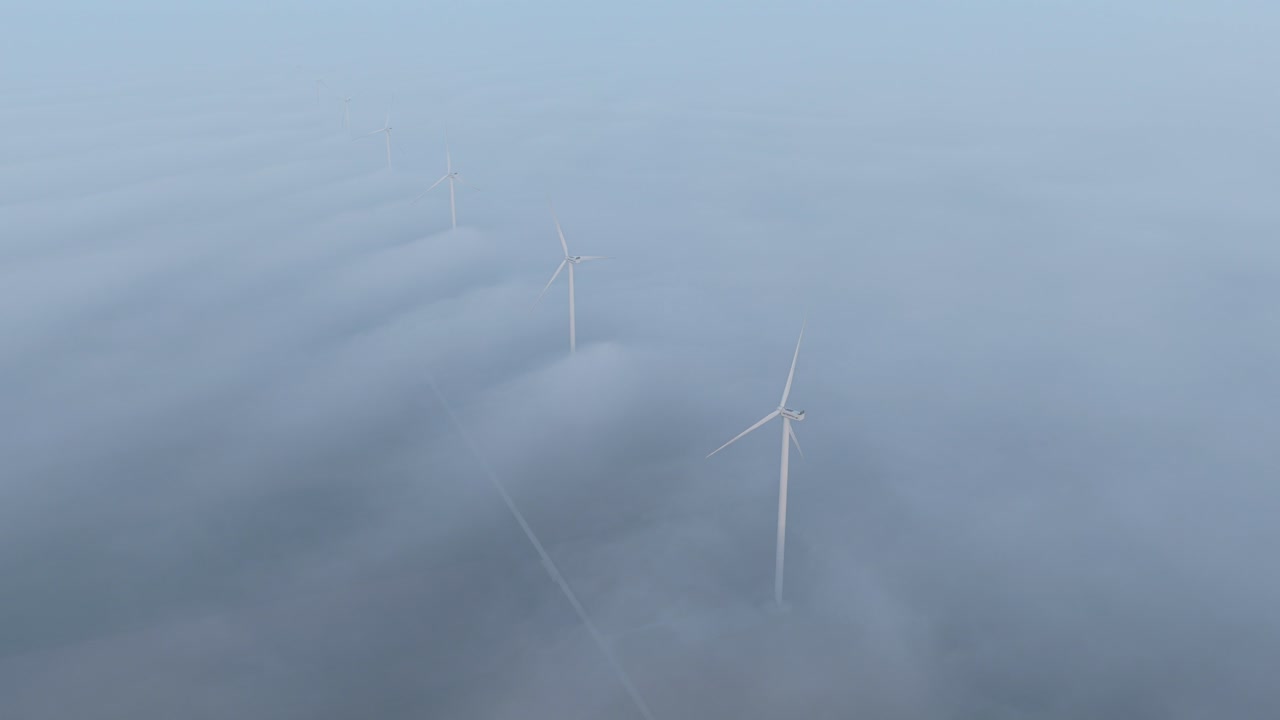 Turbine eoliche che producono energia pulita sopra la nebbia