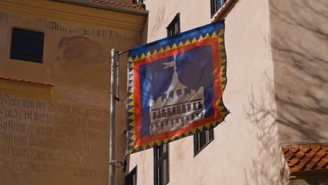 flag flapping in the wind. walls of the old castle of bran at backdrop. dracula home place in romania.
