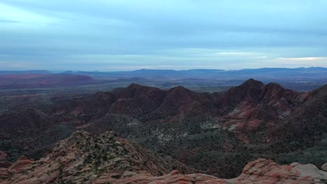 distant view of the top of the desert mountains with a view of the valley and the horizon of the blue sky with clouds