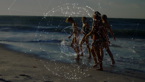 animation of globe and connections over diverse female friends walking on beach at sunset