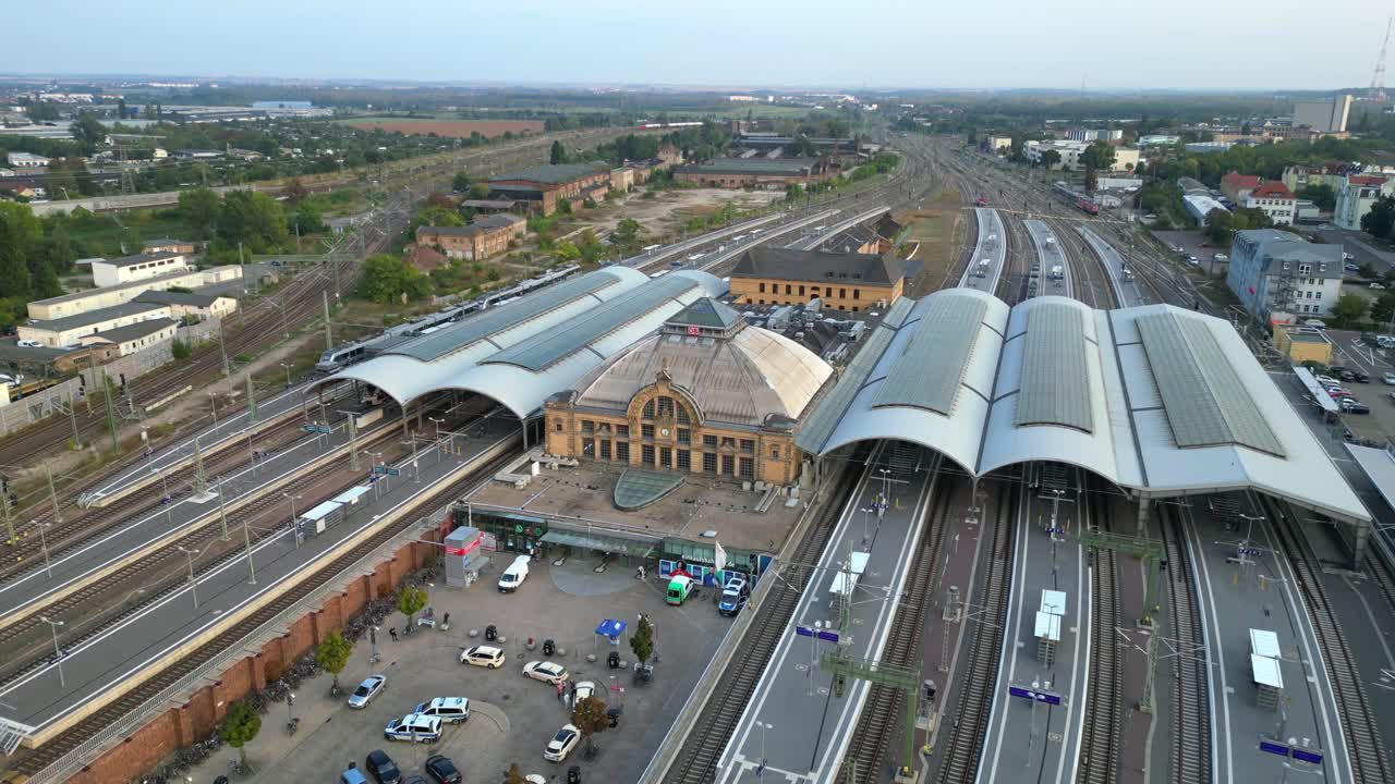 Aerial view of a modern train station with connecting tracks leading to suburbs and the city center. Best aerial view flight panorama orbit drone