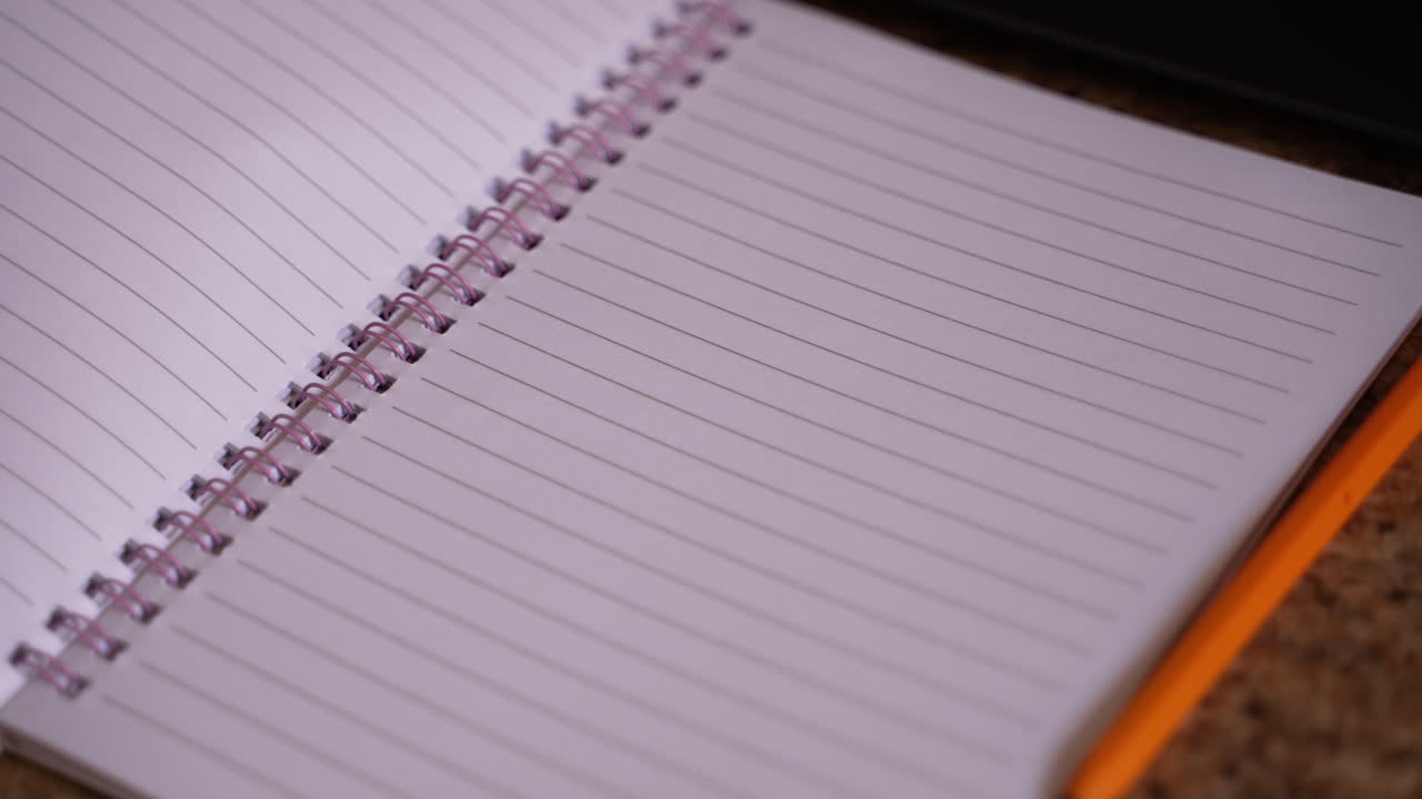 Child opening a school workbook with blank pages