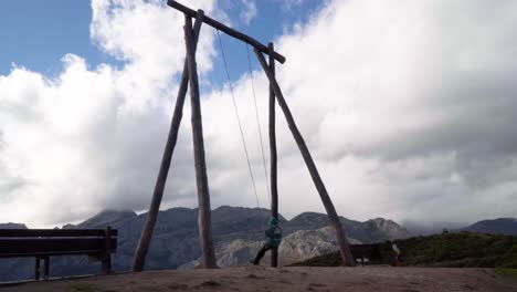 wide shot of a female swinging in a large swing set in the nature in asturias