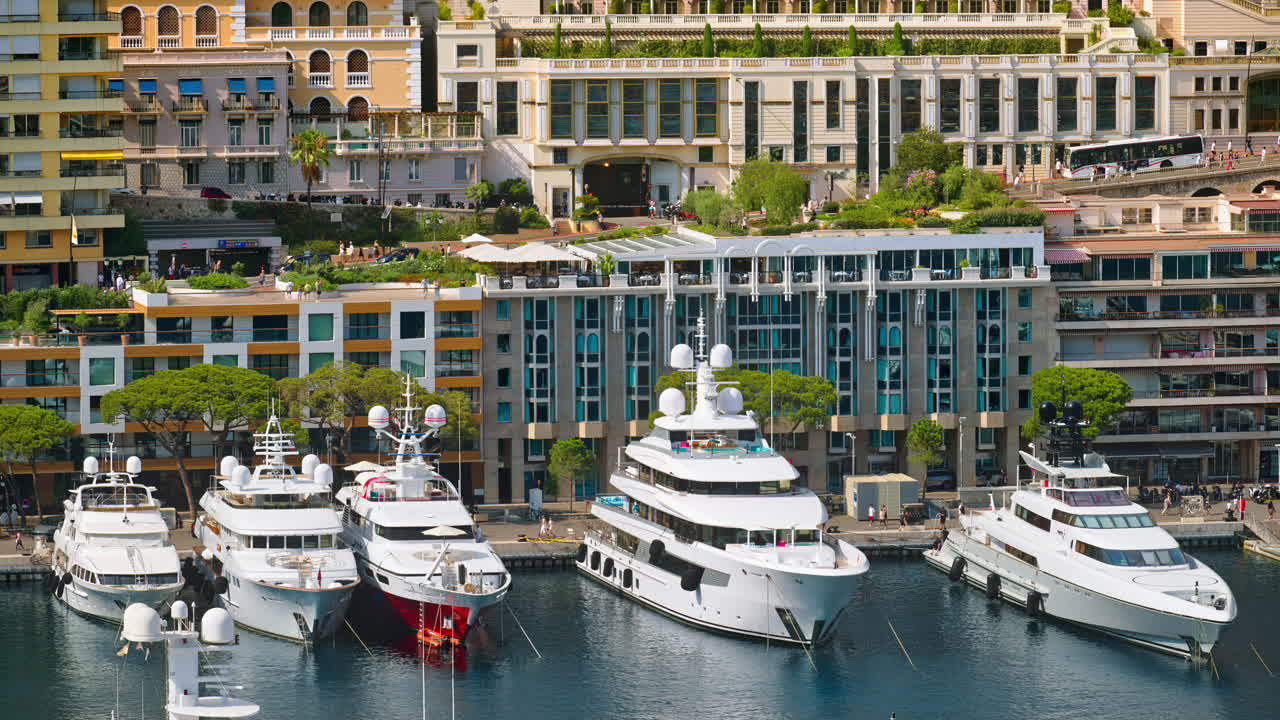View of boats docked in the Monaco Marina with the skyline of the city on the background