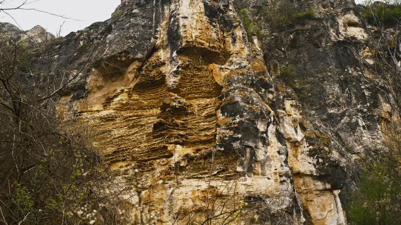 An eroded limestone slope reveals rugged textures and sharp edges, shaped by time and the elements — raw geological beauty exposed.