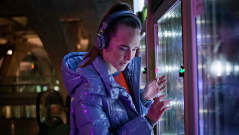 Woman-choosing-food-automat-standing-in-subway-close-up.-Girl-buying-snacks.