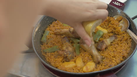 woman eating paella with chicken in restaurant