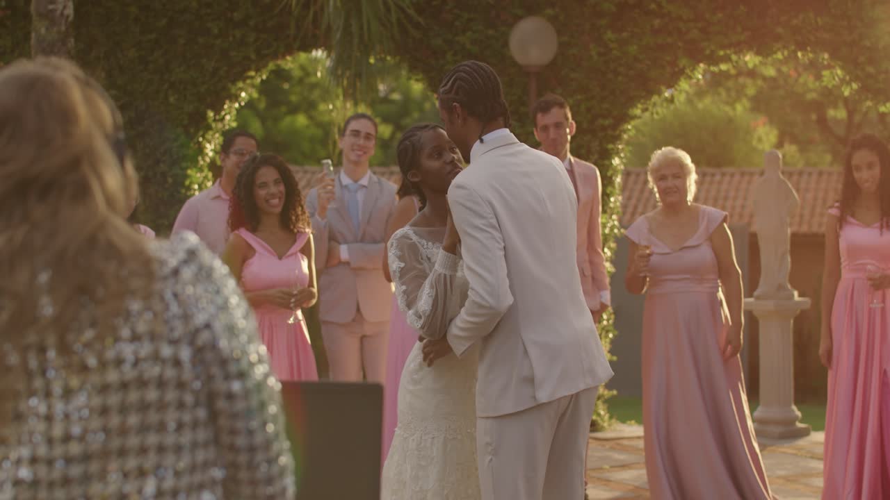 Joyful couple dances and kisses at an outdoor wedding celebration