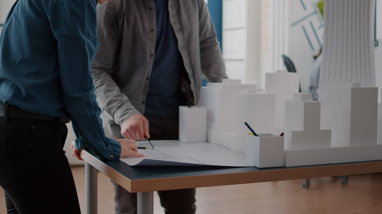 Architects review building model and blueprints in the office