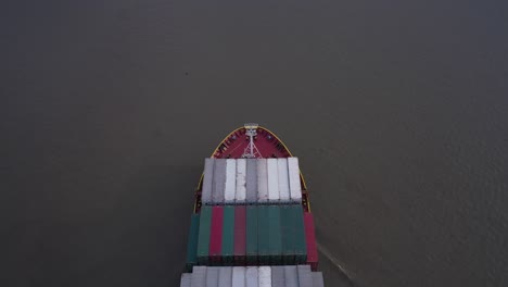 aerial top down view of heavily laden container ship navigating on the calm sea