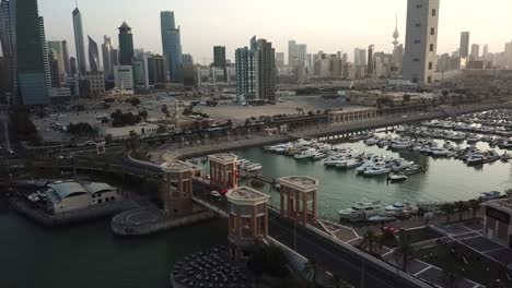sunset view in kuwait city near a marina. downward tilt aerial shot