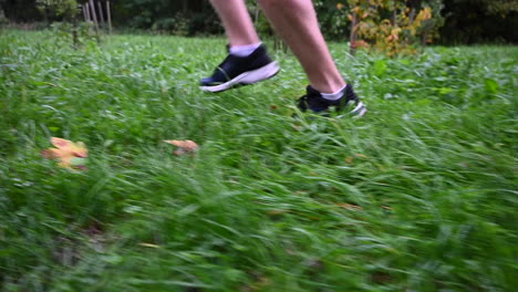 vista lateral de un corredor y sus zapatos: entrenamiento de resistencia en hierba, en la naturaleza