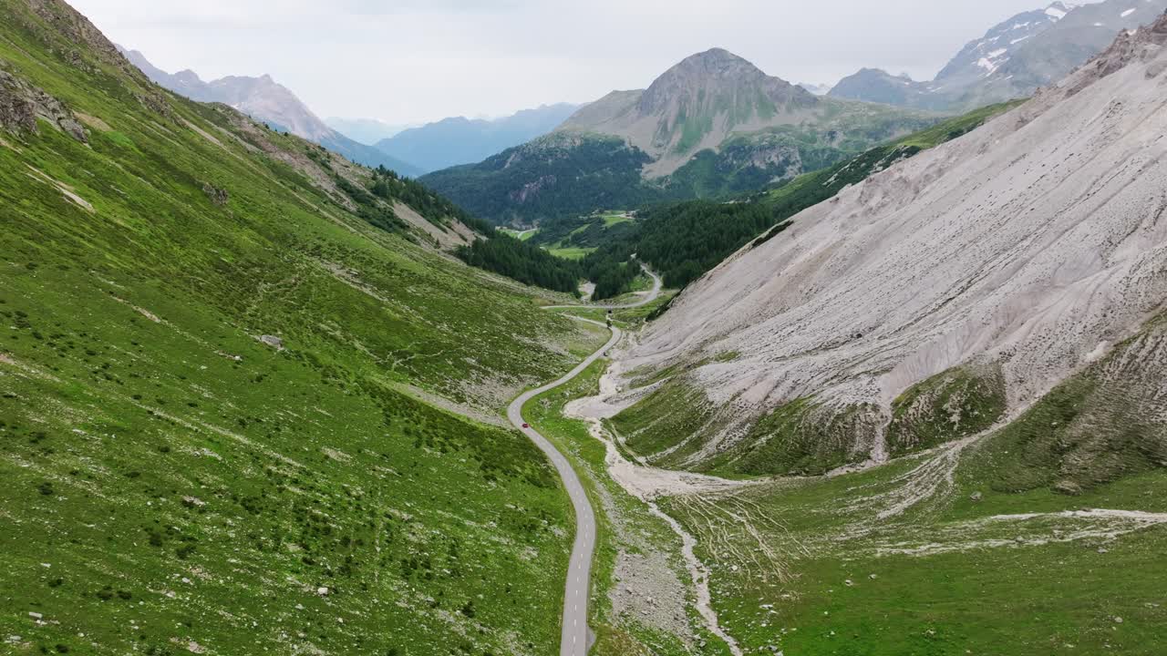 Scenic aerial Swiss Alps valley road with lone car symbolizing freedom travel