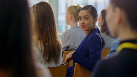 mujer de negocios sentada y sonriendo en el seminario de negocios 4k