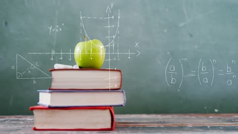 mathematical equations floating against apple on stack of books