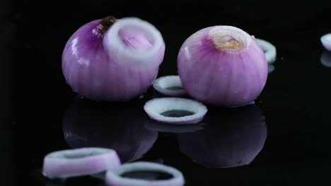 rewind clip of fresh onion rings falling on bulbs of red onion