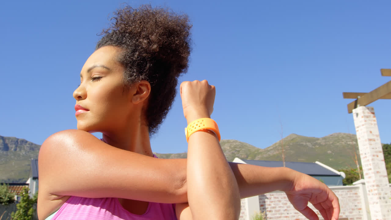 vista de bajo ángulo de una joven bonita mujer de raza mixta haciendo ejercicio en el patio trasero de la casa 4k
