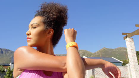 Low-angle-view-of-young-pretty-mixed-race-woman-exercising-in-backyard-of-home-4k