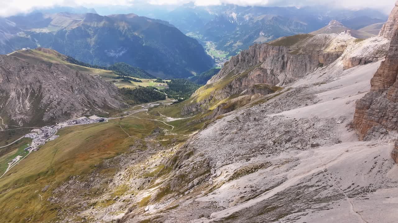 There is a view from the Sella massif of the Pordoi Pass. Cable cars running
