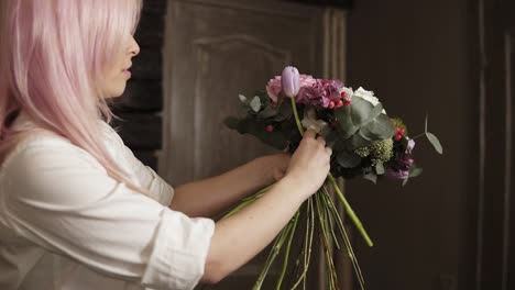 a young woman gathered a stunning bouquet of flowers, complements it with a purple tulip. close frame of a bouquet