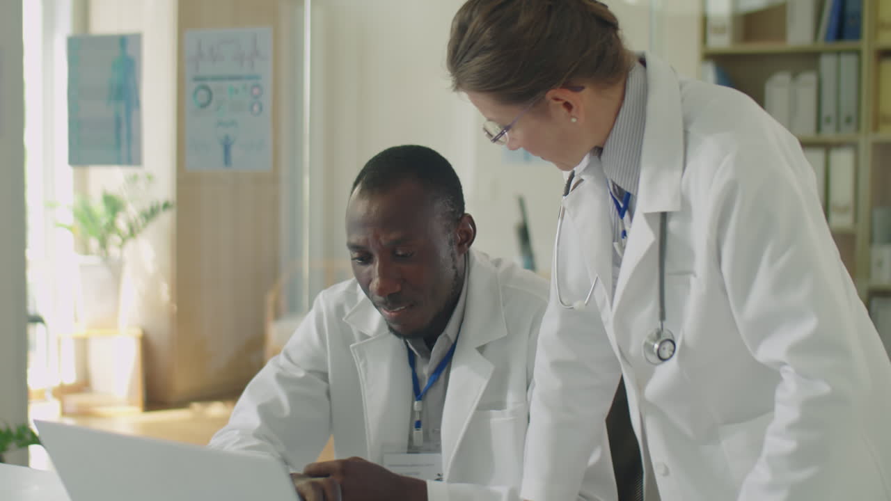 Multiethnic Doctors Working Together on Laptop in Clinic