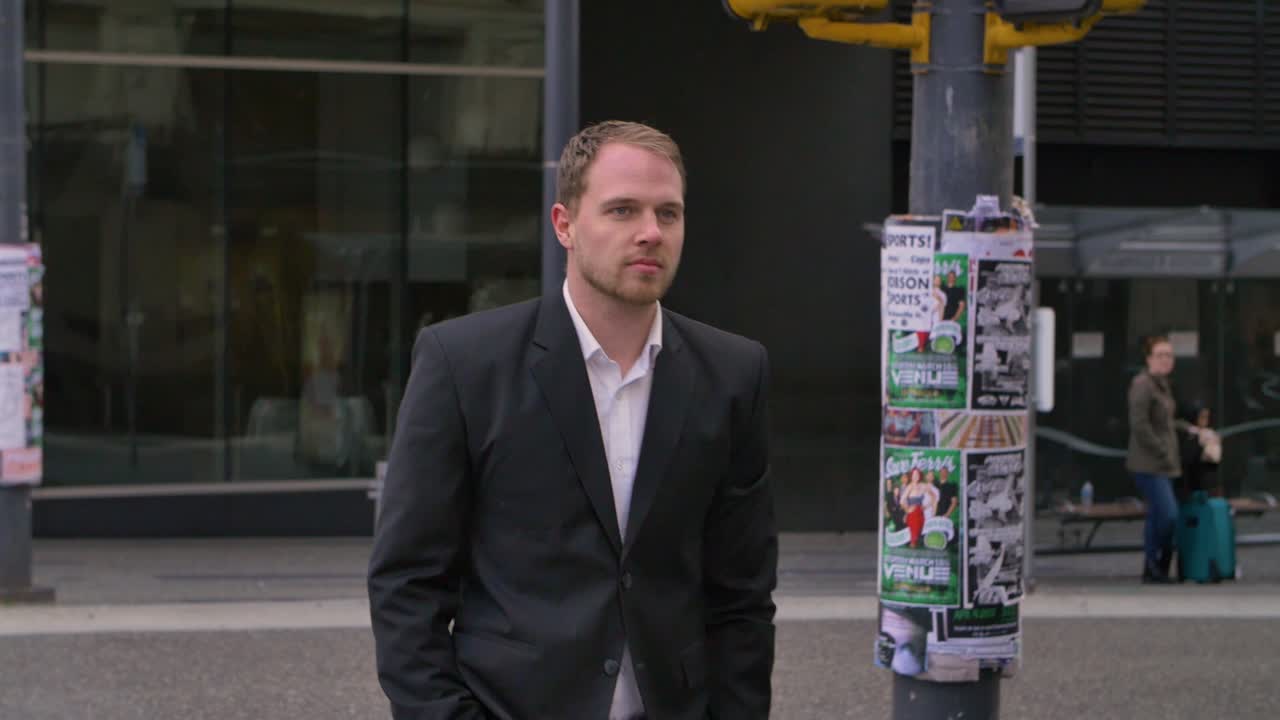 A young business man walks across the street in Vancouver's downtown core