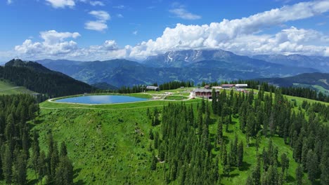 with beautiful mountain range background, family sports pool sits above hill of trees