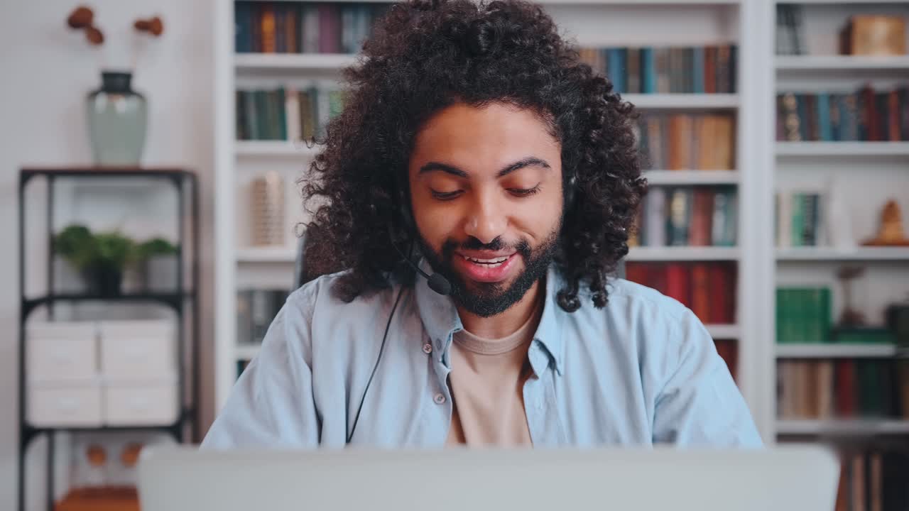 Young arabian man call center employee in headset sits at table with laptop