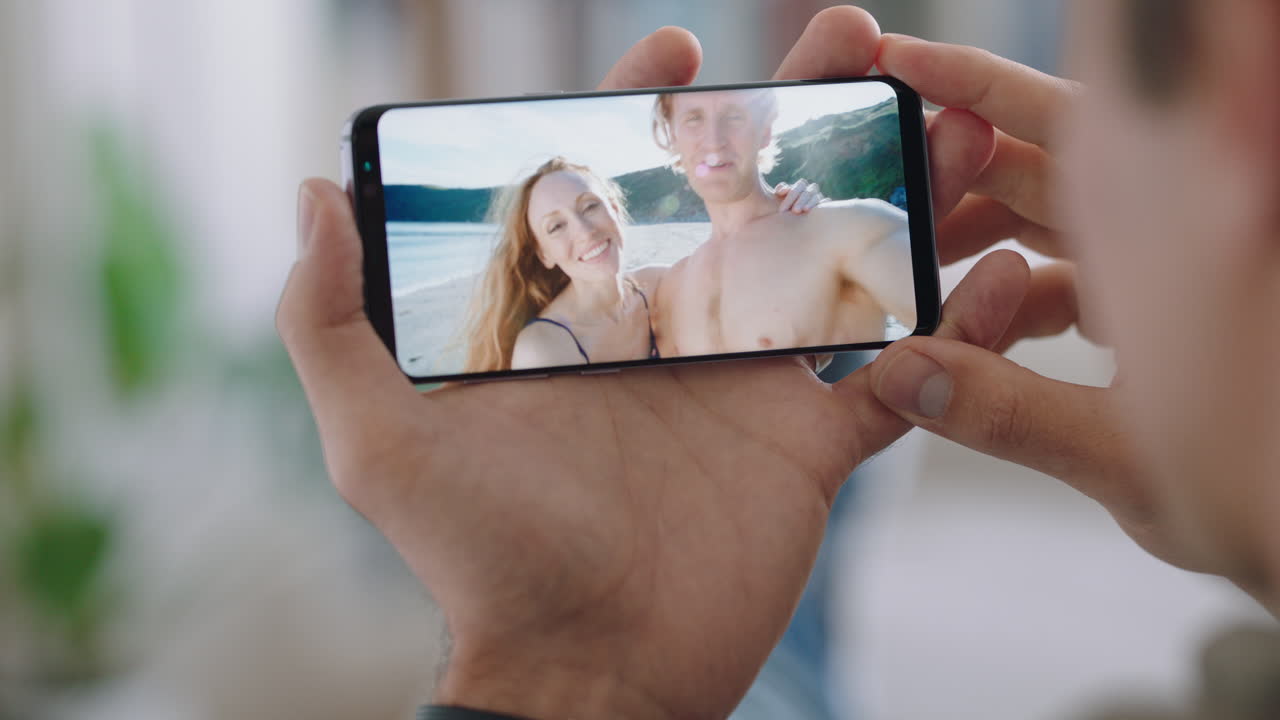 joven chateando por video usando un teléfono inteligente pareja en vacaciones de luna de miel compartiendo experiencia de viaje amigos disfrutando de diversión aventura de vacaciones comunicándose en teléfono móvil 4k