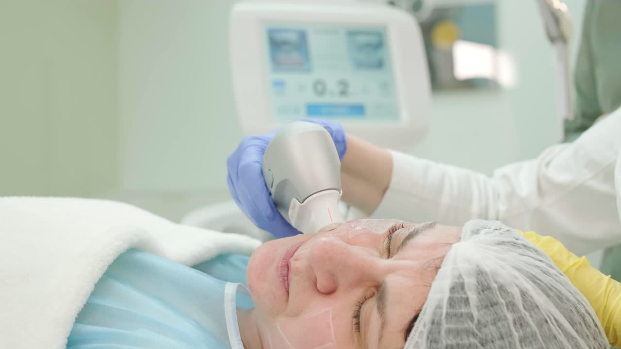 전문적인 얼굴 피부 재생, 리프팅 절차. 미용사는 현대적인 초음파 장치를 사용합니다. 하드웨어 미용