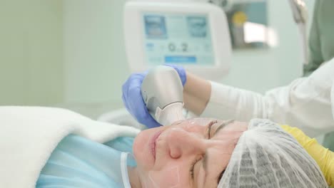 professional face skin rejuvenation, lifting procedure. cosmetologist uses modern ultrasound device. hardware cosmetology