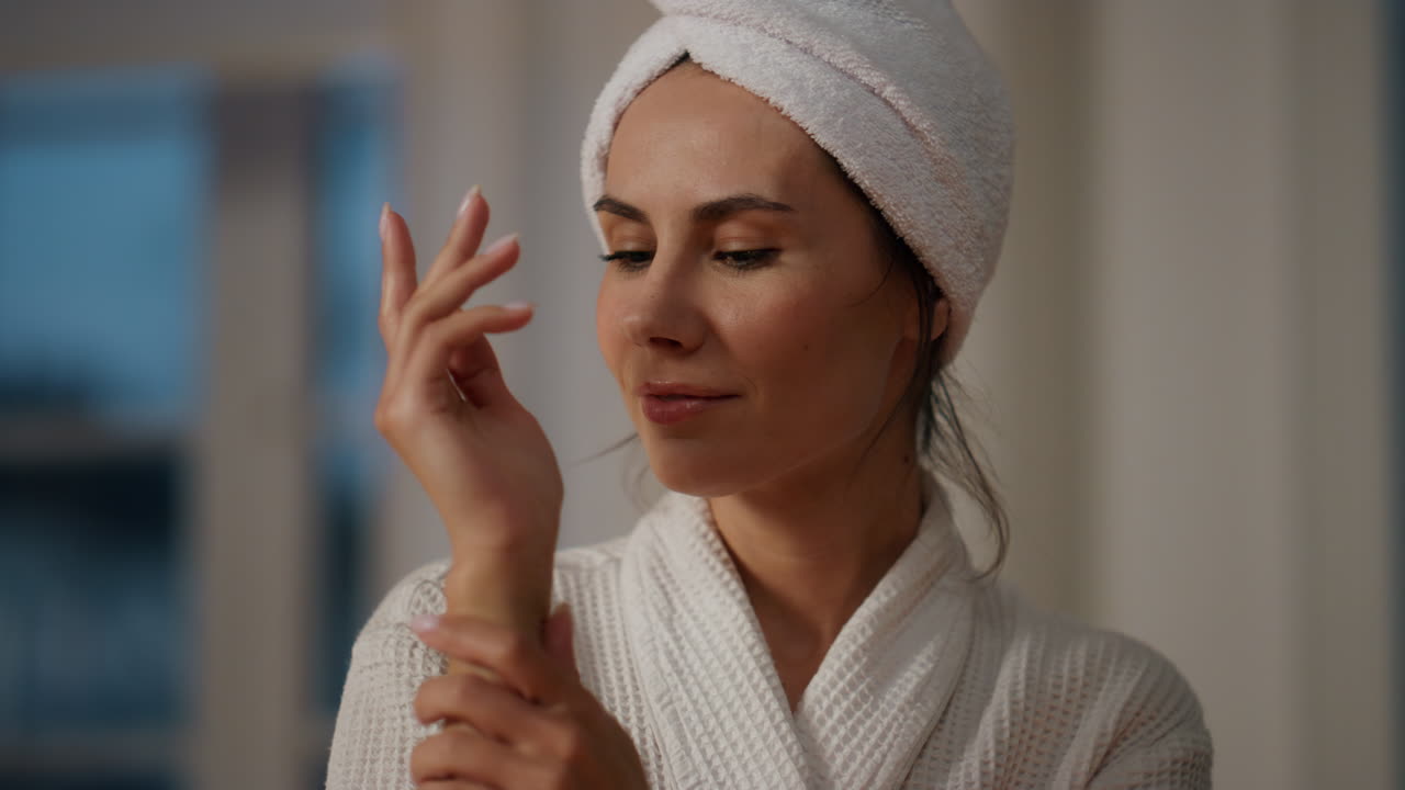Calm model creaming hands home close up. Resting lady applying cream at evening