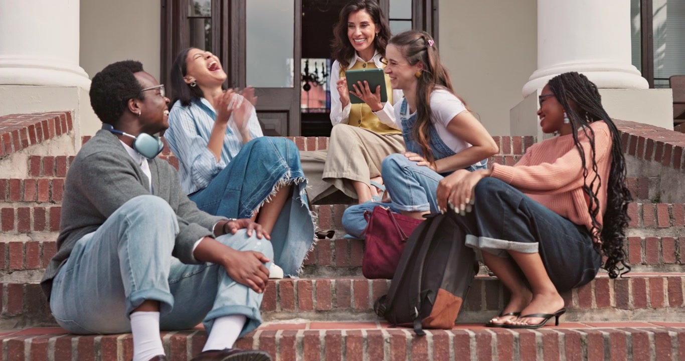 Diverse Group of Students Sitting on Campus Steps Using Tablet