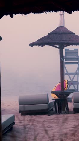 misty beach scene with umbrellas and lounge chairs