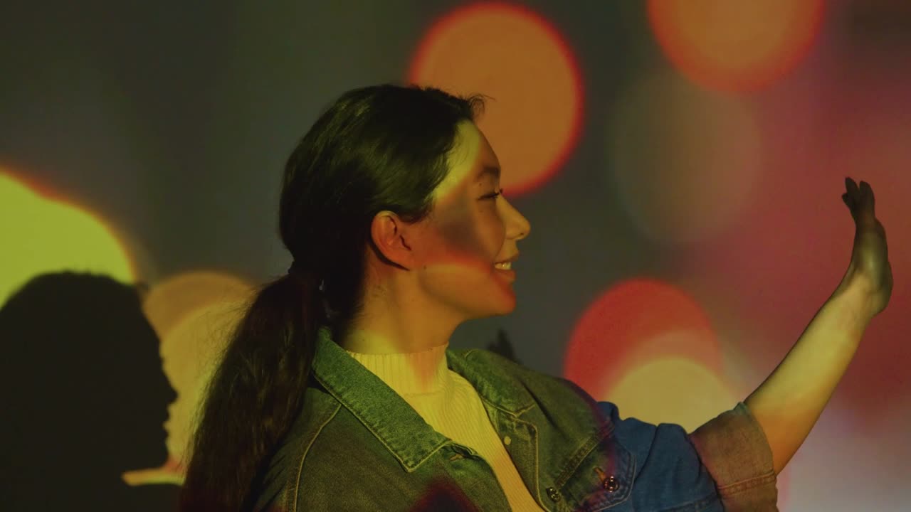 그녀의 얼굴에 이미지가 투사되는 몰입 예술 전시회를 방문하는 여성 2