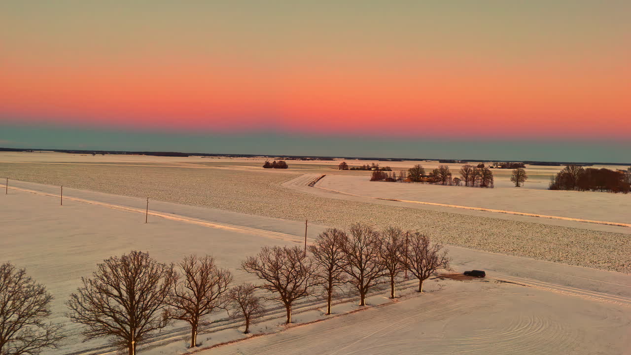 Drone footage of a frozen European countryside at dusk