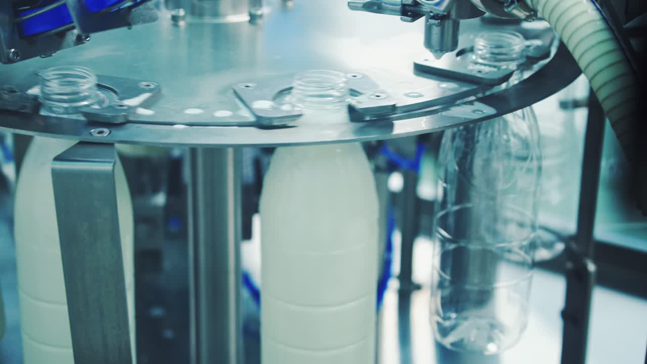 Plastic bottles filling with milk. Milk pouring into plastic bottle at dairy plant