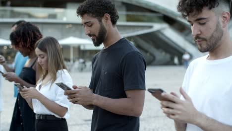 cheerful people using digital devices while walking