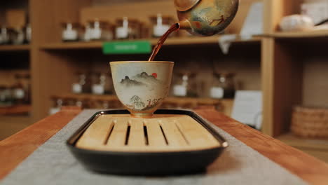 pouring tea into a decorative ceramic cup