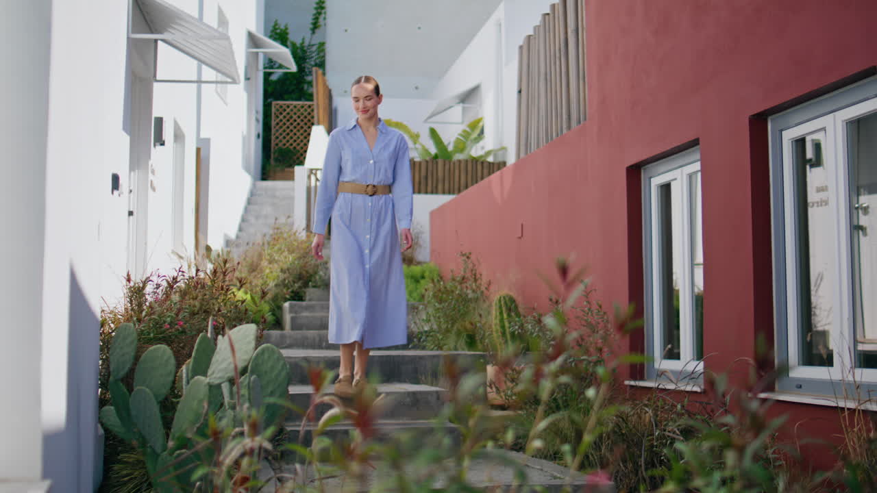 Turista che scende le scale alla luce del sole estivo. Modella elegante in relax