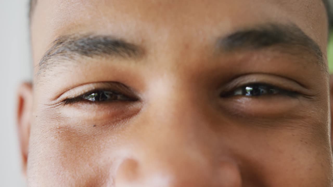 Portrait of happy african american male teenage boy at home, slow motion