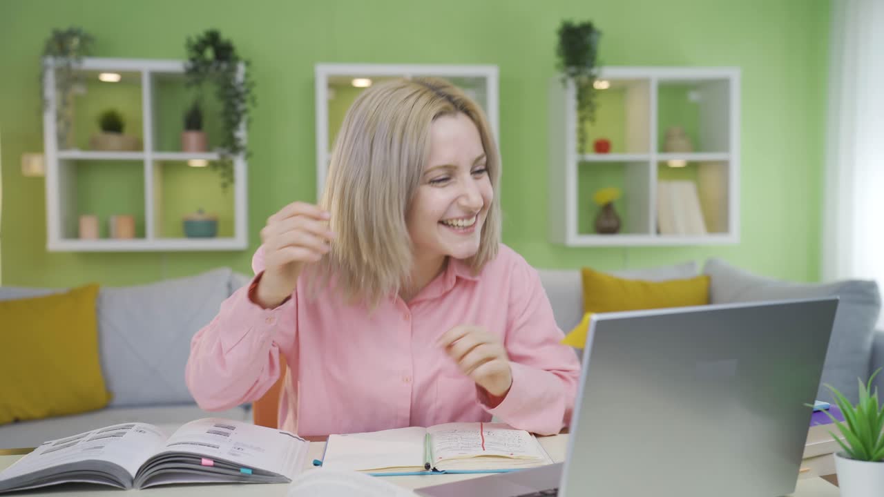 대학생 소녀는 컴퓨터에서 보는 것에 만족합니다.