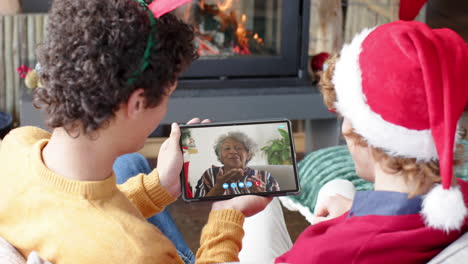 Happy-diverse-male-friends-and-senior-mother-having-christmas-tablet-video-call,-slow-motion