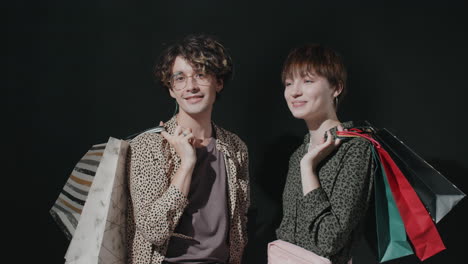 portrait of young happy man and woman with shopping bags