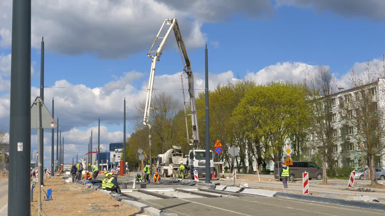 Road construction, pouring concrete against a blue sky background