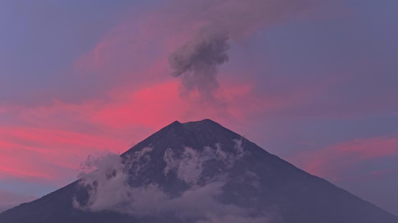 Vulcano Semeru che erutta fumo durante una splendida alba rosa.