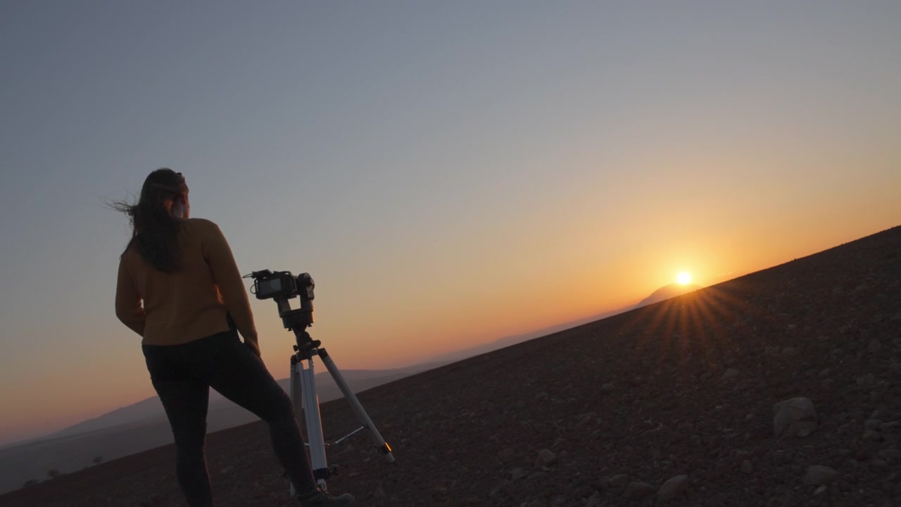 Kvinde filmer solnedgangen i ørkenen