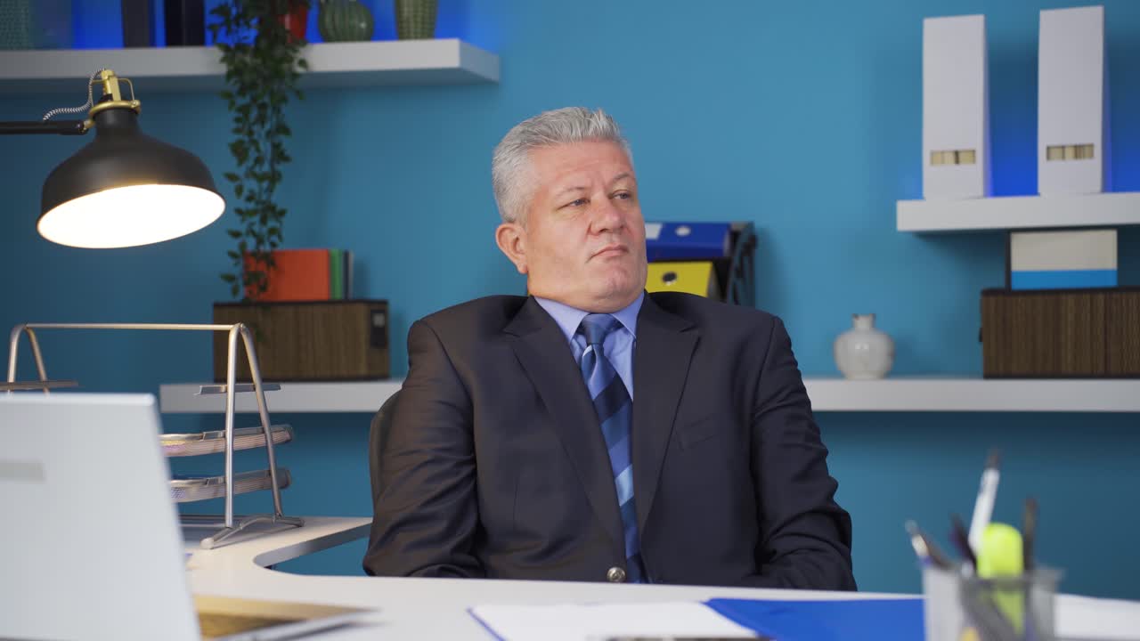 un hombre de negocios soñoliento bosteza mirando a la cámara.