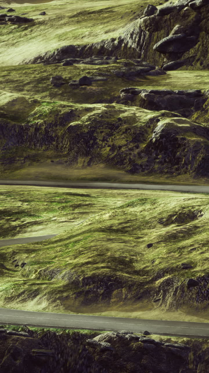 Winding road through green mountains under a golden sky at dusk